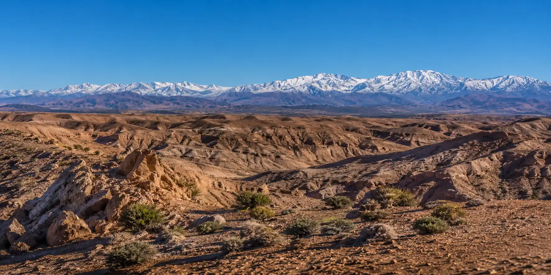 Panoramic view of Agafay Desert rocky landscape with Atlas Mountains